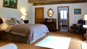 A bedroom with a bed, a dresser, a mirror, and a door leading to another room. - Le Farat (Auvillar)