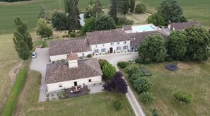 Un'ampia tenuta con diversi edifici, una piscina e un campo da tennis.