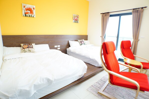 A hotel room with two beds, a red chair, and a window with curtains. - Warm B&B (Baisha)