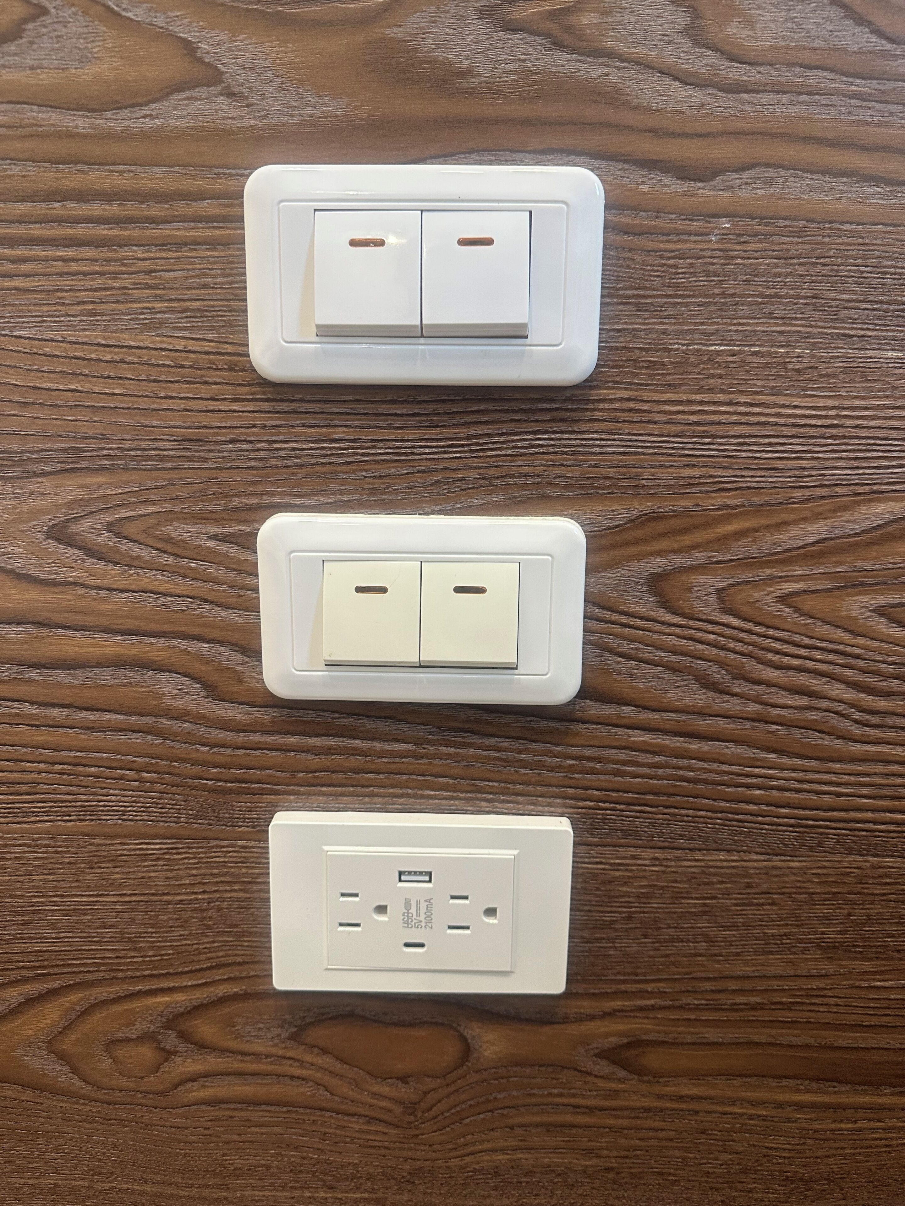 Three electrical outlets on a wooden surface.