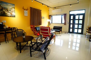 Una habitación con una mesa de comedor, sillas, un sofá y un ventanal con cortinas.