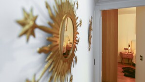 A room with a large mirror, a wooden door, and a nightstand with a lamp. - PARAISOL 3 Family Complex (Salou)