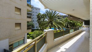 A balcony with a tiled floor, a railing, and a view of a building with multiple windows and balconies. - PARAISOL 3 Family Complex (Salou)