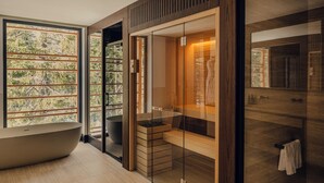 Een moderne badkamer met een vrijstaand bad, een douche met glazen wanden en een wastafelmeubel met spiegel.