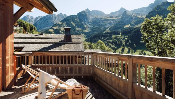 Una terraza de madera con vistas a montañas.