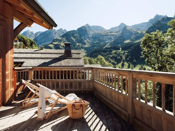 A wooden deck with a view of mountains. - 4★ Chalet, 14 pers, steam room, near slopes, south terrace (La Clusaz)
