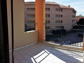 Enjoy a view of the city from this balcony with a metal railing and a small window.