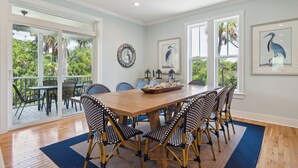 Un espace repas avec une table en bois, des chaises à motifs noirs et blancs, et un tapis bleu.