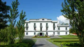 A large, white building with a symmetrical facade, multiple windows, and a central entrance.