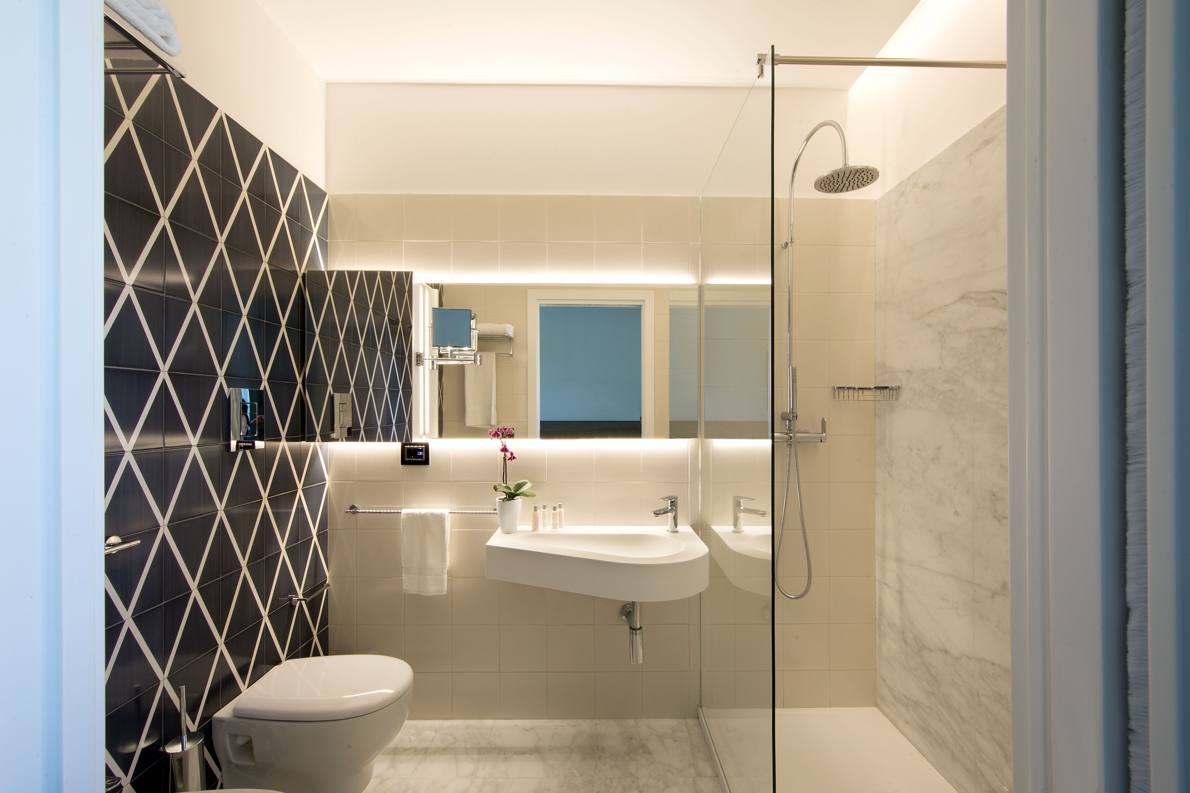Un baño moderno con inodoro, lavabo y ducha.