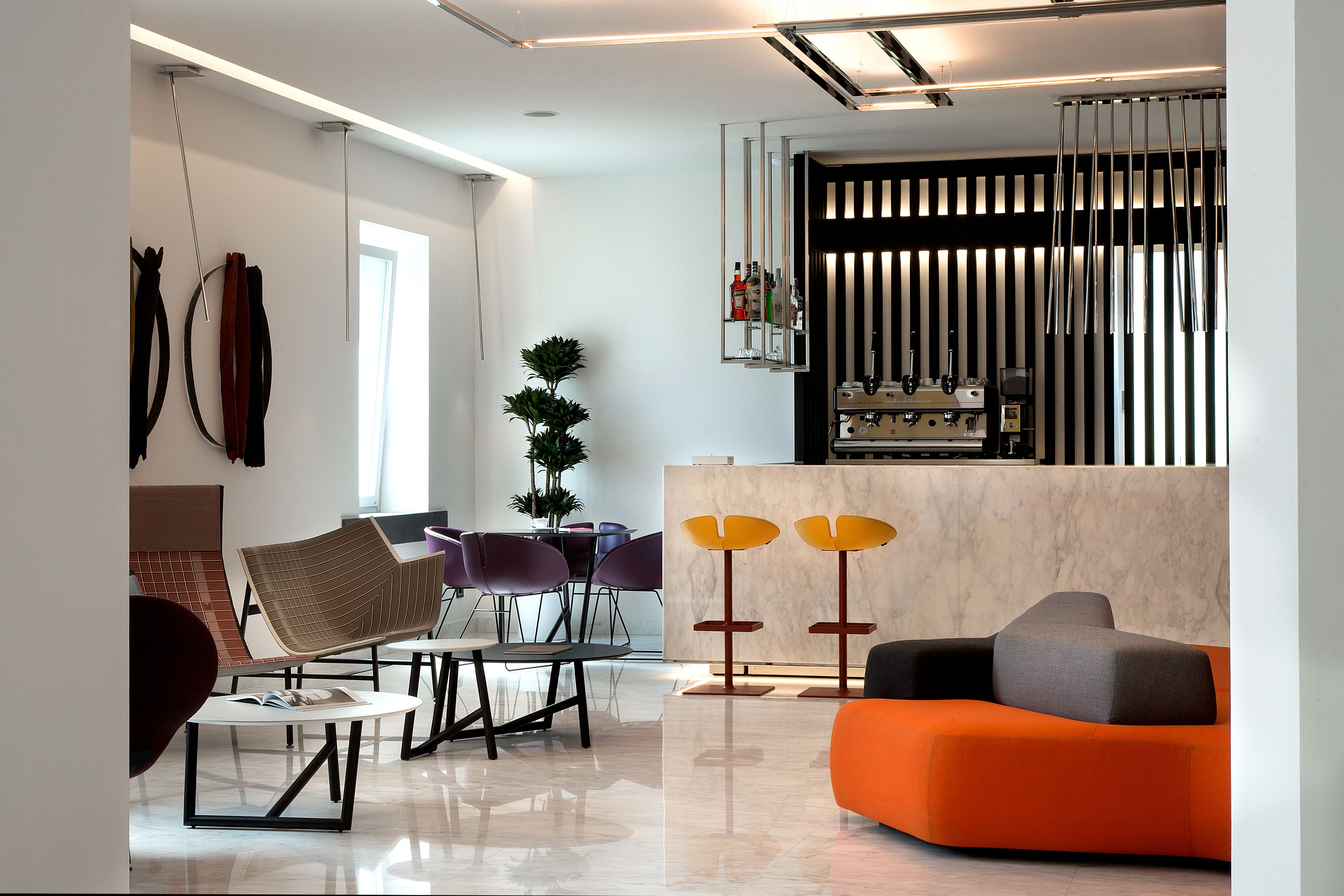 A modern living room with a sofa, chairs, a coffee table, and a dining area with a table and chairs.