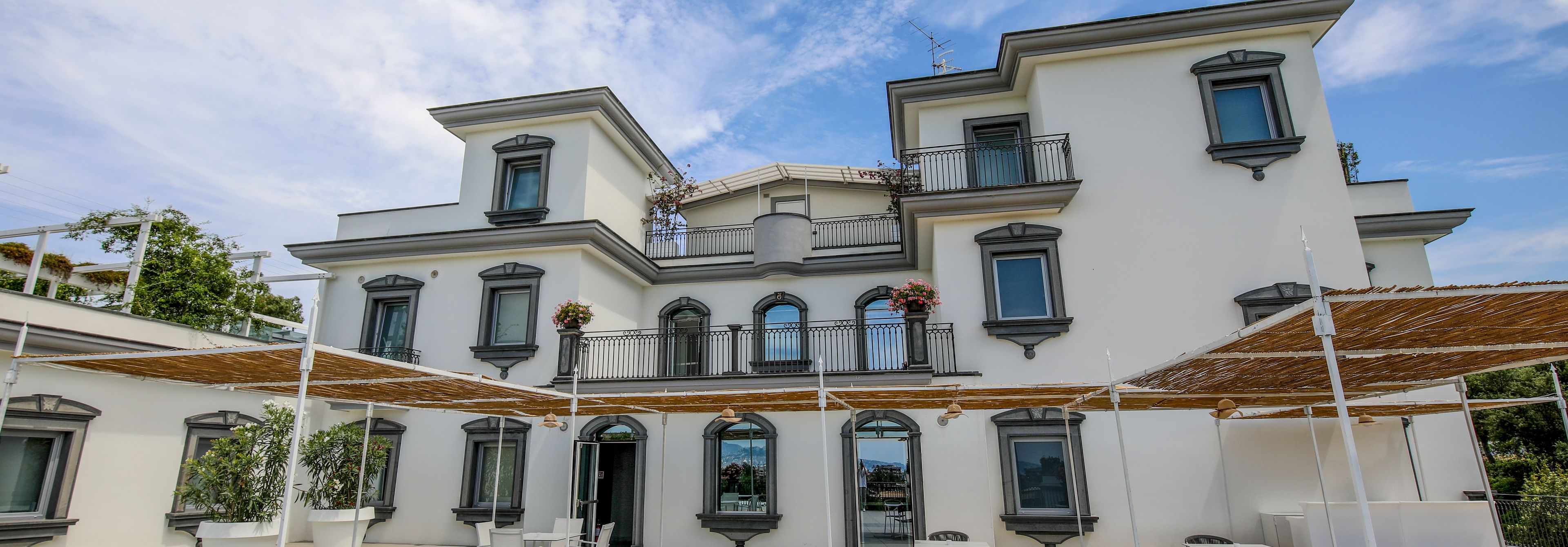 A multi-story building with balconies, large windows, and outdoor seating areas.