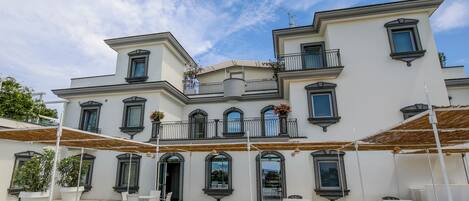 A multi-story building with balconies, large windows, and outdoor seating areas.