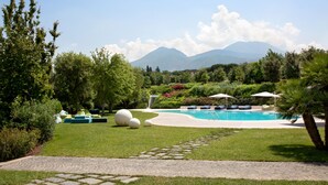 A pool area with lounge chairs and a clear view of mountains in the background. - Il San Cristoforo (Ercolano)