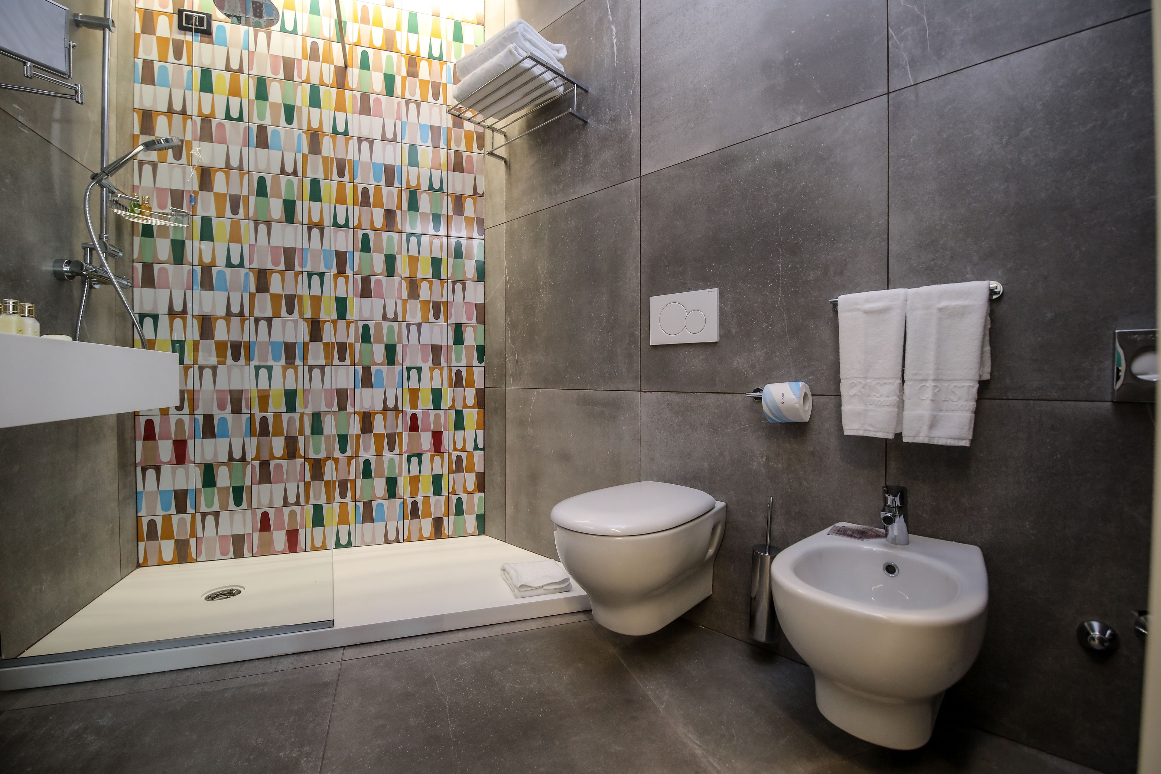 A modern bathroom with a shower, toilet, and bidet.