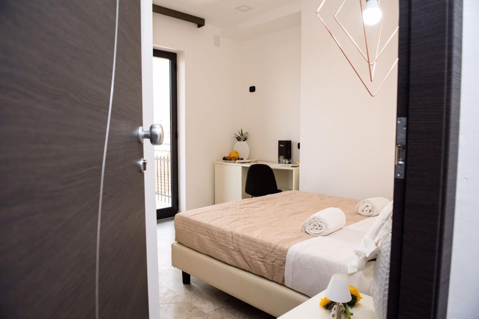 Un dormitorio moderno con una cama, un escritorio y una silla.