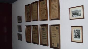 Een muur met meerdere ingekaderde documenten en foto's.