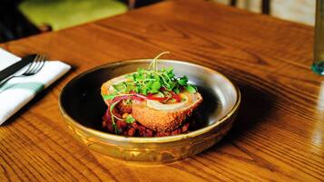 Un plato con vegetales verdes y rojos sobre una mesa de madera.