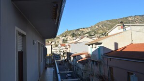 A narrow street with buildings on both sides, a clear sky, and a hill in the background. - Hotel la Spagnola (Amantea)