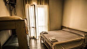 A room with a single bed, a wooden desk, and a window with curtains. - Hotel la Spagnola (Amantea)