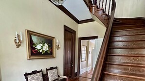 A wooden staircase with a dark finish and a glass ceiling light fixture. - The Wynne House Inn (Holly Springs)