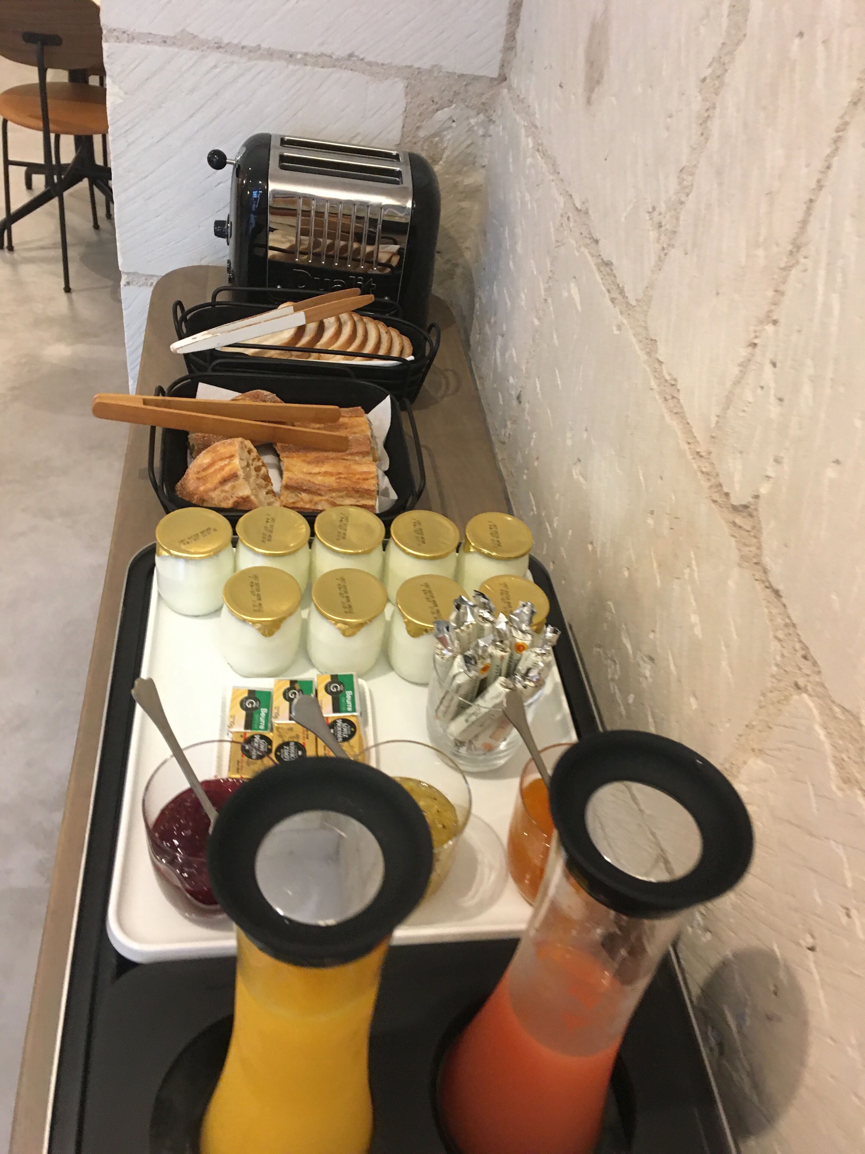 Een ontbijtbuffet met diverse soorten eten, sauzen en een broodrooster.