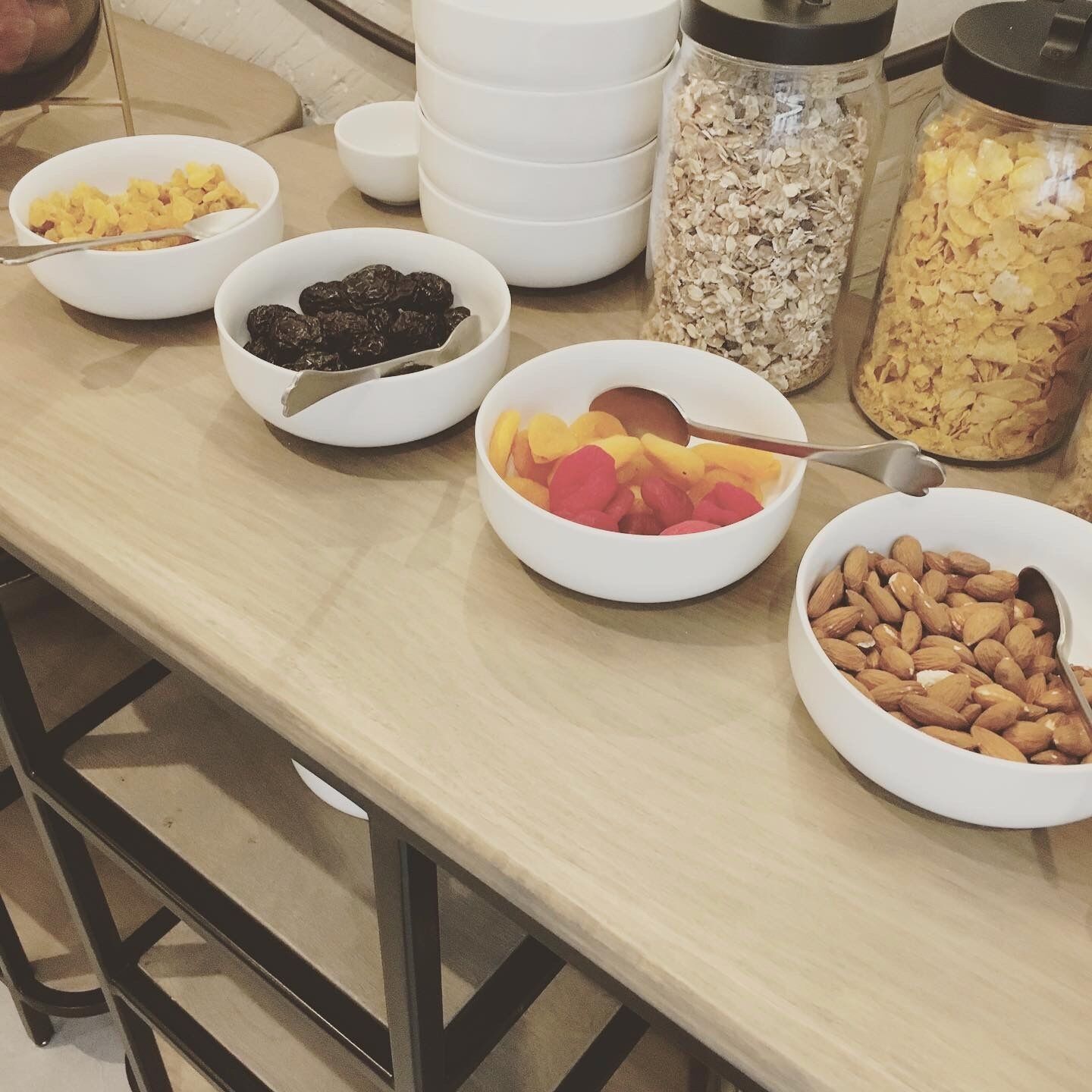 A breakfast buffet with various food items in bowls and jars.
