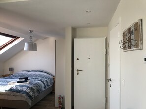 A bedroom with a bed, a door, and a window. - Exclusive Flats Sainte-Catherine Terrace (Brussels)