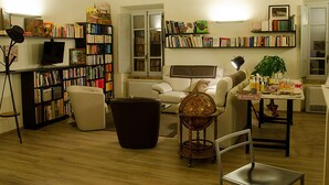 Un salon confortable avec une bibliothèque, un canapé, une table basse et un téléviseur.