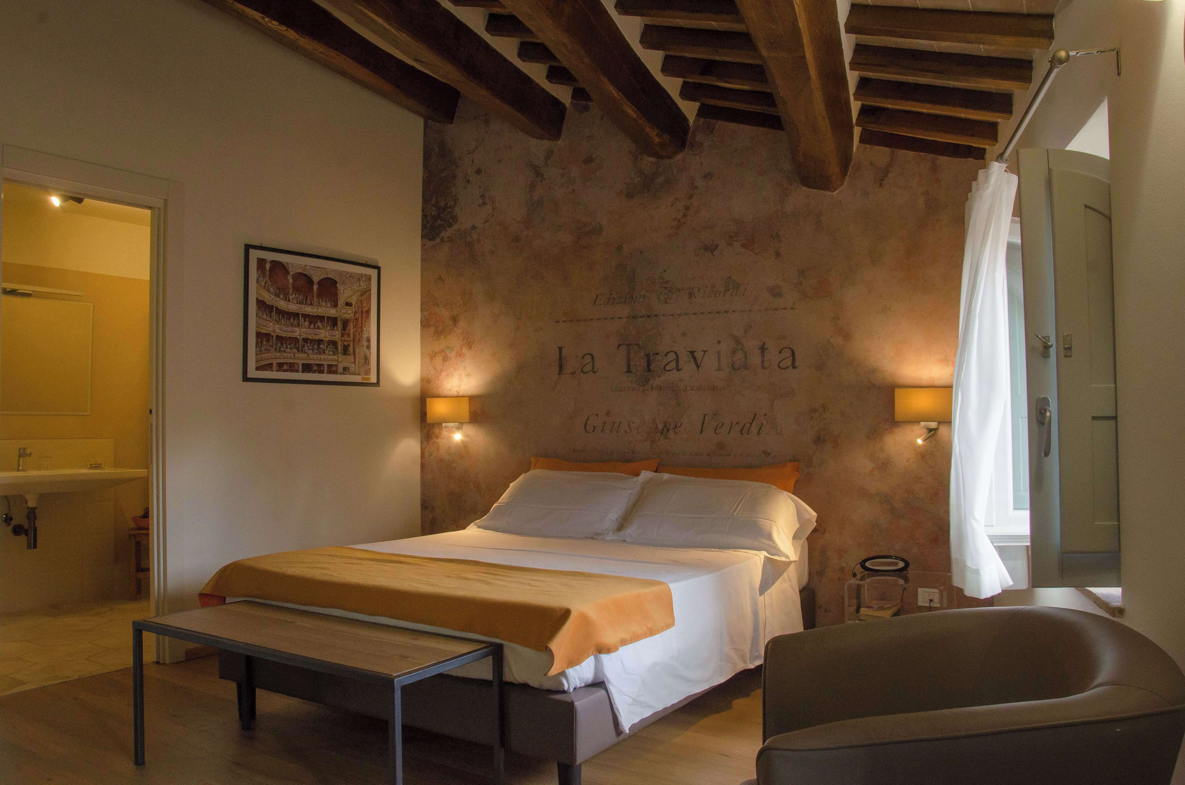 Une chambre à coucher avec un lit, une table de chevet et un mur orné d’une affiche.