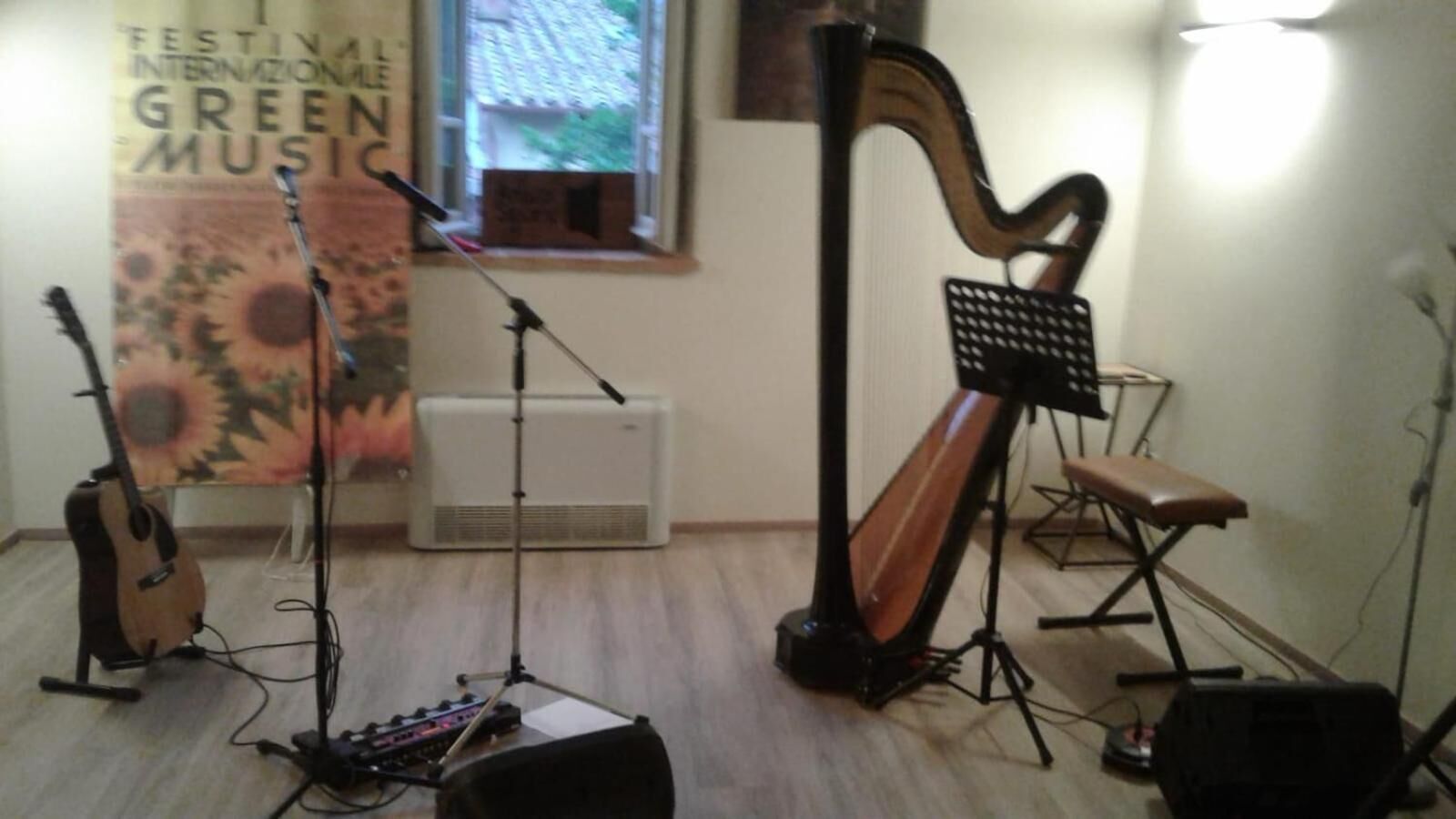 Una habitación con arpa, guitarra y piano, lo que sugiere un espacio dedicado a la música.