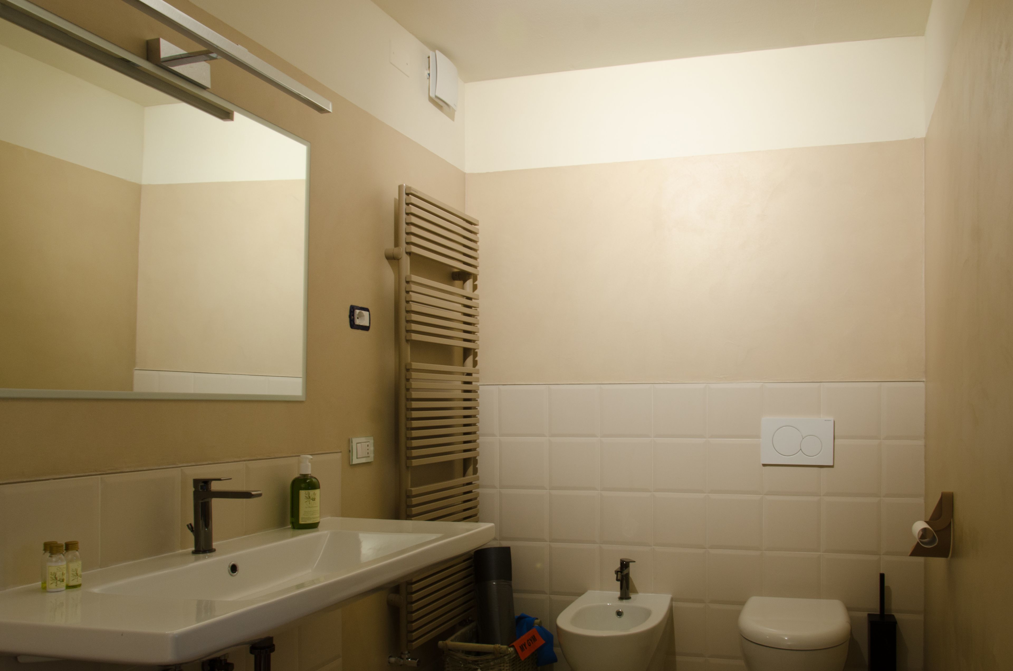 A bathroom with a sink, bidet, toilet, and towel rack.