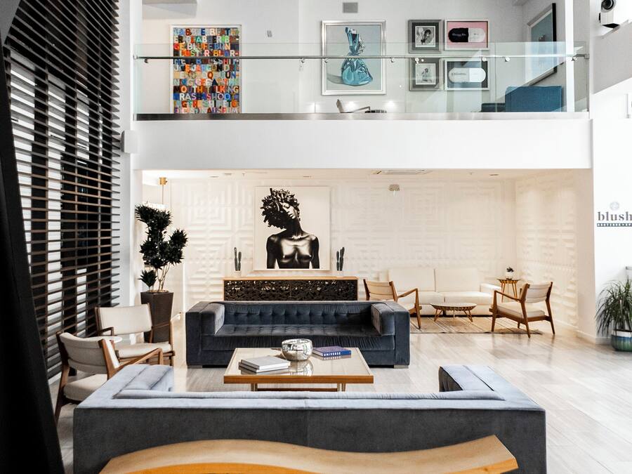 A modern interior with a central seating area, a glass railing, and artwork on the walls.