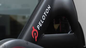 A close-up of a Peloton exercise bike with a sleek, black design and a red logo.