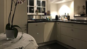 A modern kitchen with a window, a sink, and a countertop with various items. - Exclusive Flats Studio Swimming-pool (Dilbeek)