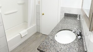 A bathroom with a bathtub, a sink, and a shower.