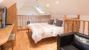 Une chambre confortable située sous les toits, avec un lit, un bureau et une chaise.