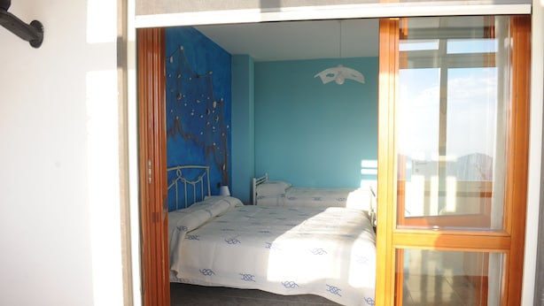 Ein Schlafzimmer mit einem Bett, einem Sessel und einem Fenster.