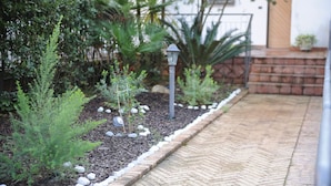 Ein Gartenpfad mit Ziegelsteinkanten und einem Metalllichtmast.