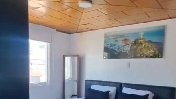 A bedroom with a bed, a painting on the wall, and a window. - Hotel Normandia Gold (Bogotá)