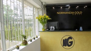 A reception desk with a black backdrop and the logo 'NG' at the center. - Hotel Normandia Gold (Bogotá)