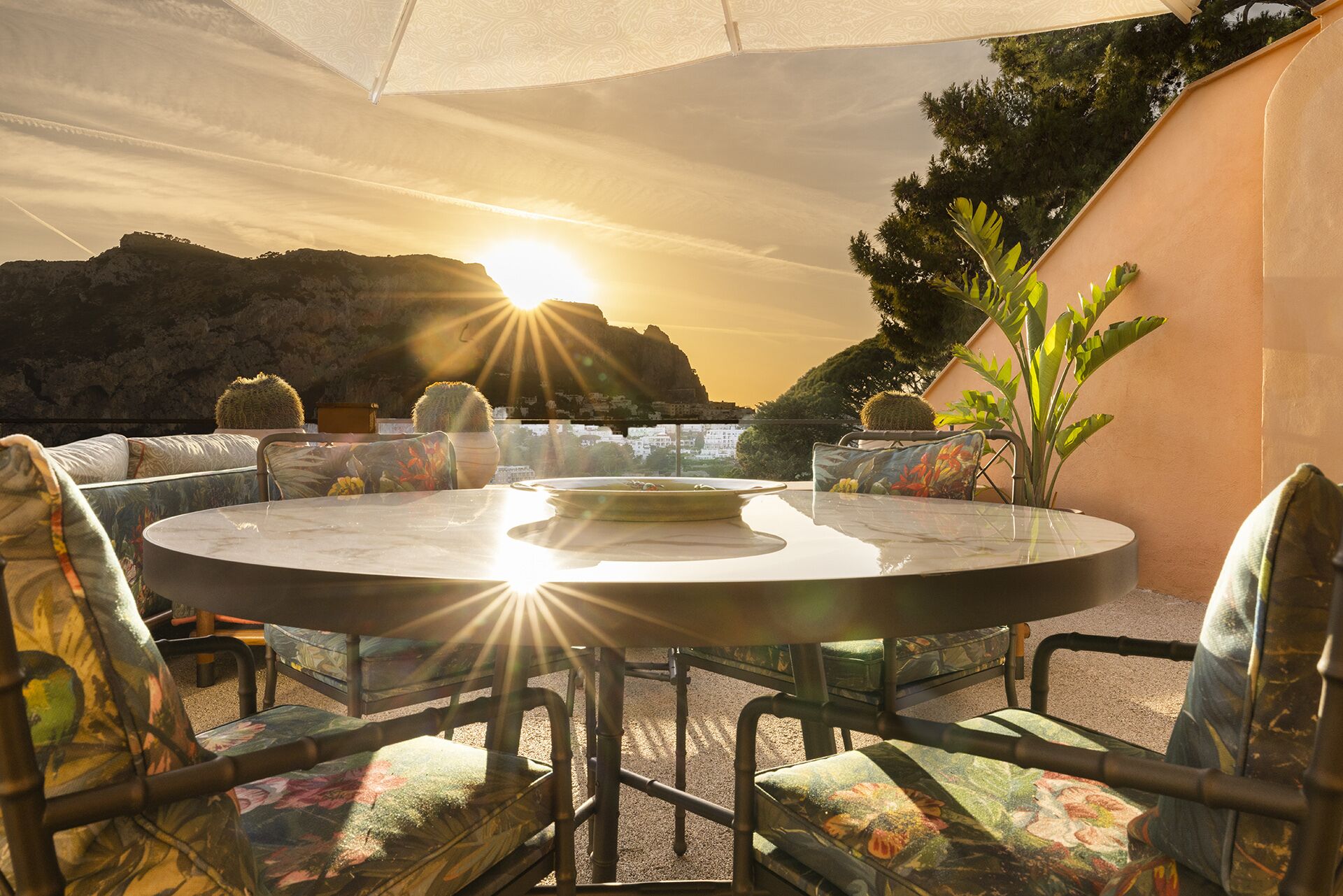 Una mesa redonda con sillas, un toldo y vistas a un paisaje montañoso.