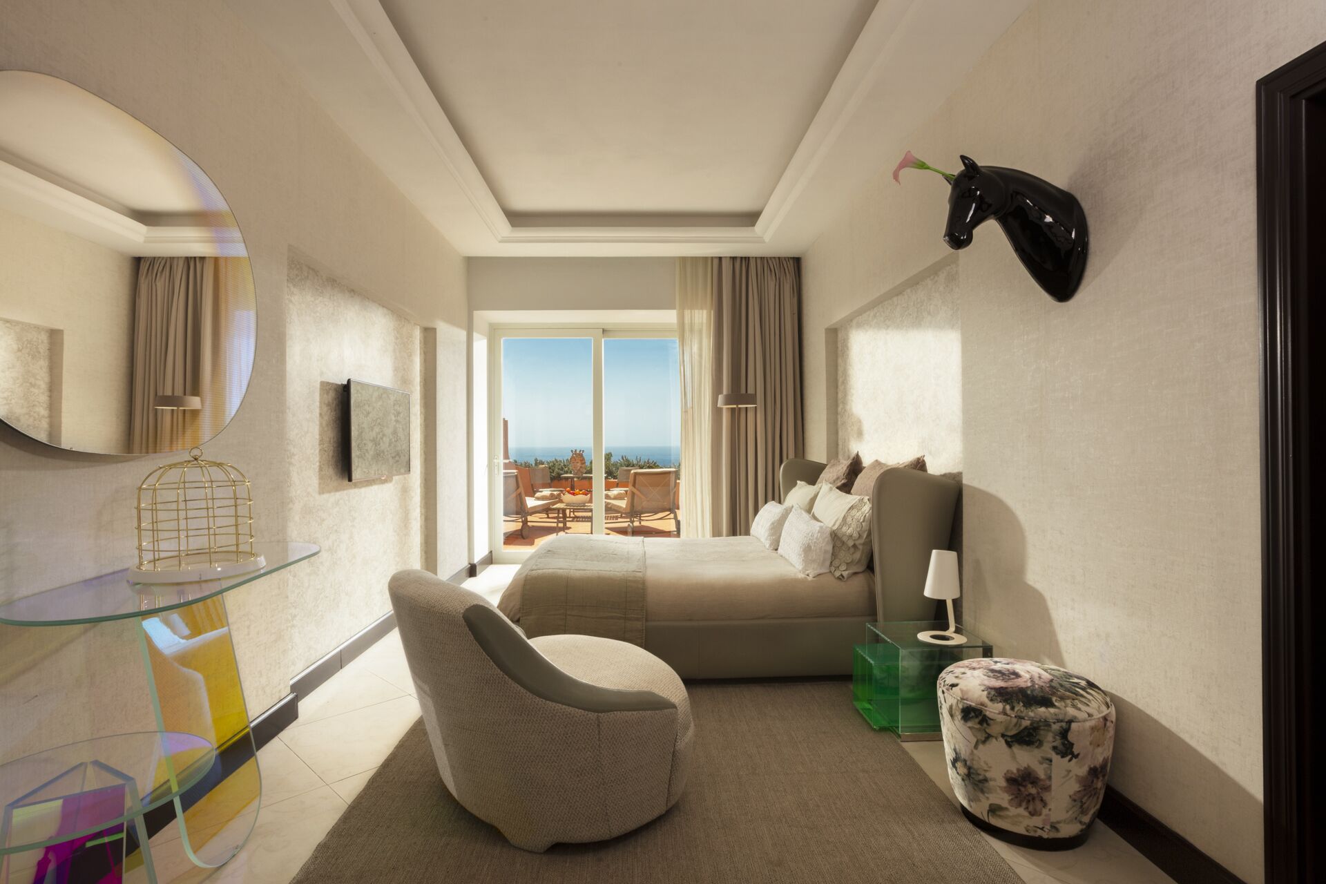 Une chambre d’hôtel moderne équipée d’un lit, d’un coin salon, d’une table en verre et offrant une vue sur l’extérieur.