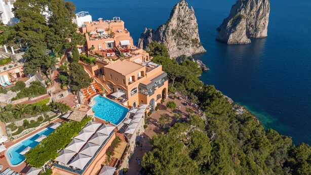 A coastal hotel with a pool, terraced balconies, and views of the sea and cliffs. - Hotel Punta Tragara (Capri)