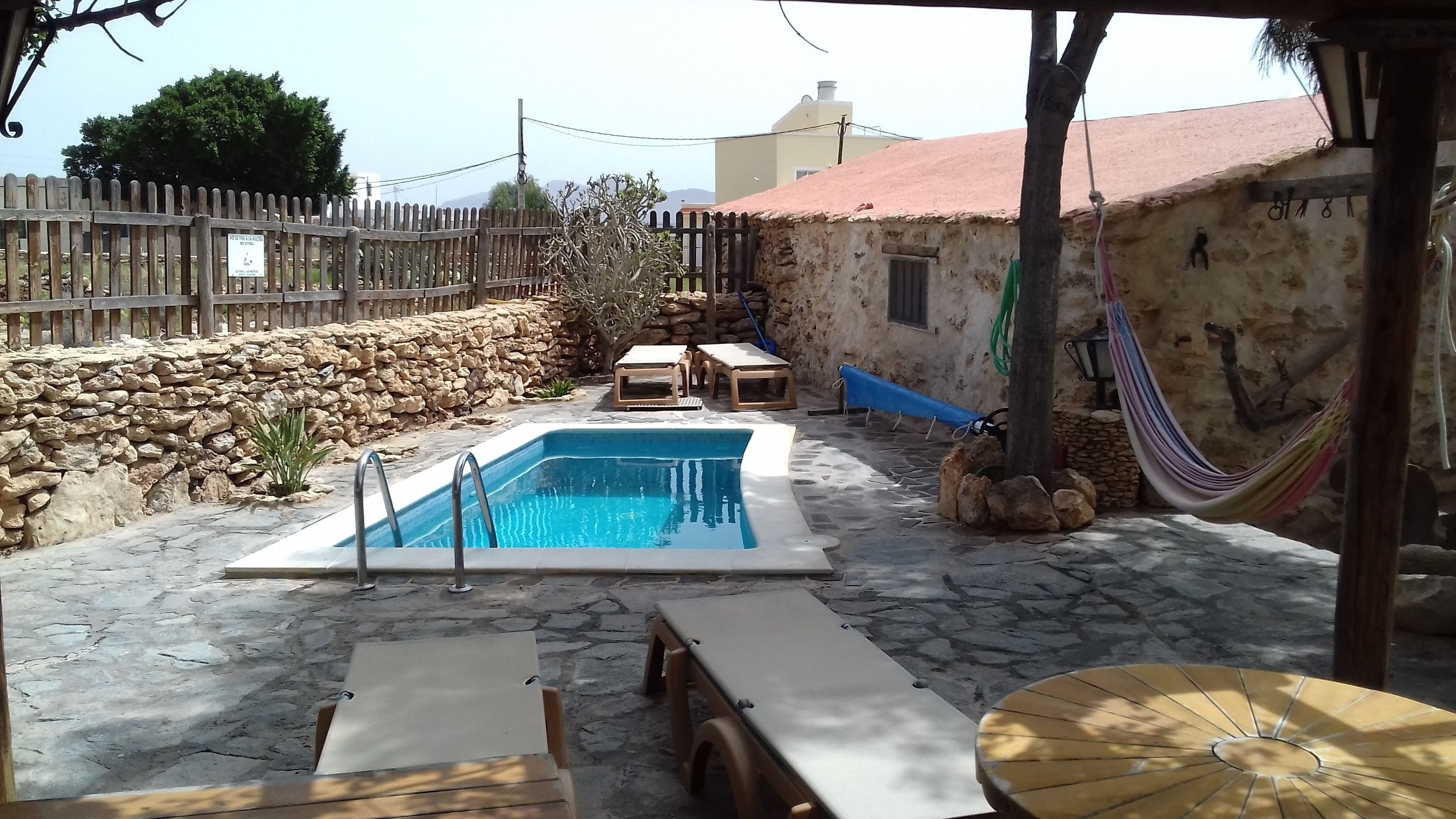 Een buitenzwembad en ligstoelen