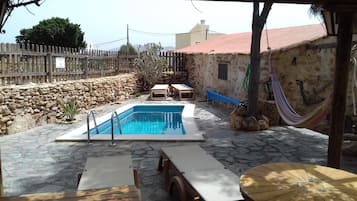 Een buitenzwembad en ligstoelen