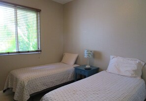 A room with two beds, a nightstand, and a window with blinds. - Splendor by 123cape VR (Cape Coral)
