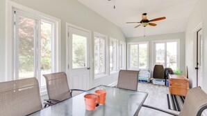 A spacious room with a large glass table, multiple chairs, and a ceiling fan. - Walk to Pawcatuck River: Family-Friendly Home! (Pawcatuck)