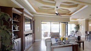 Un espacio habitable amplio con un ventanal grande, un ventilador de techo y una mesa de comedor con sillas.