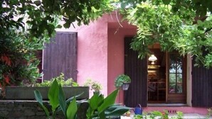 A pink building with dark shutters, a stone wall, and potted plants in the foreground. - Residence with character (Pont-Saint-Esprit)